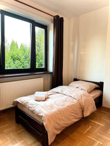 a bed in a room with a large window at Hotel Familiar in Kobyłka