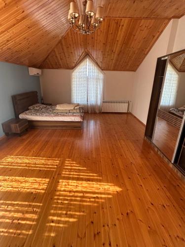 a large room with a bed and a wooden floor at Kingasimov in Baku