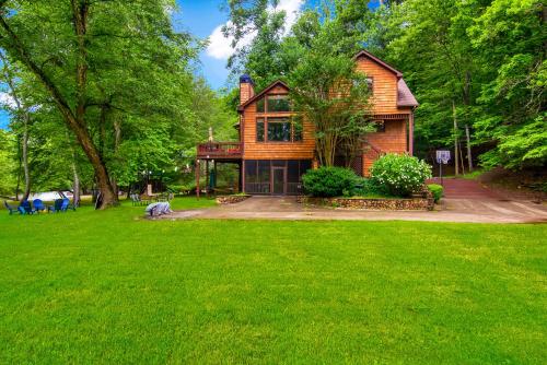 ein Haus mit einem grünen Rasen davor in der Unterkunft Cabin Zen, Riverfront, Hot Tub, Arcades, Sleeps 8 in Ellijay