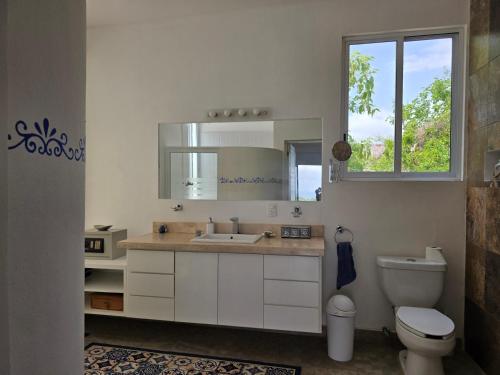 a bathroom with a sink and a toilet and a mirror at Villa Monte Aragón in San Agustinillo