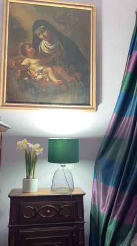 a painting on the wall above a table with a lamp at Art action room in Villanovafranca