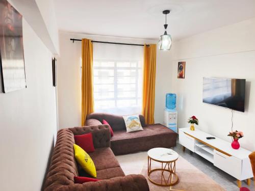 a living room with a couch and a table at Kate's Ksm CBD apartments 3br2br1br O7Oo1FourFour22Eight in Kisumu