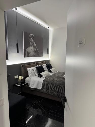 a bedroom with a bed with a picture on the wall at Bonheur Luxury Rooms in Ercolano