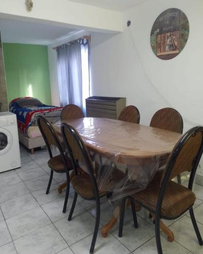 a dining room with a wooden table and chairs at Ad-ma-da in Epuyén