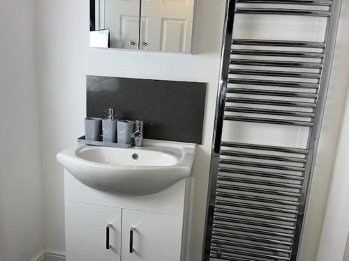 a bathroom with a sink and a mirror at Home In Maidstone in Maidstone