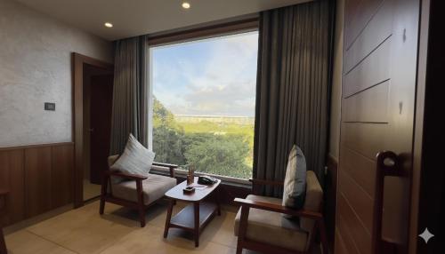 a room with a large window and a table and chairs at Ra Vista in Kolkata