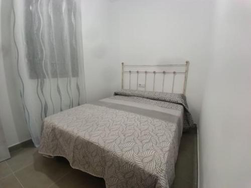 a small bed in a room with a curtain at Sweet hause carril 23 in Caravaca de la Cruz