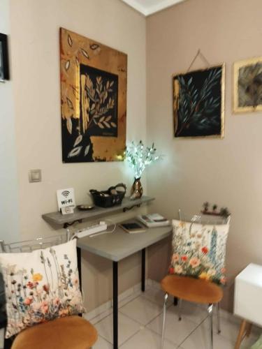 a room with a desk with two chairs and a table at Cozy studio, 1min from Kamara in Thessaloniki