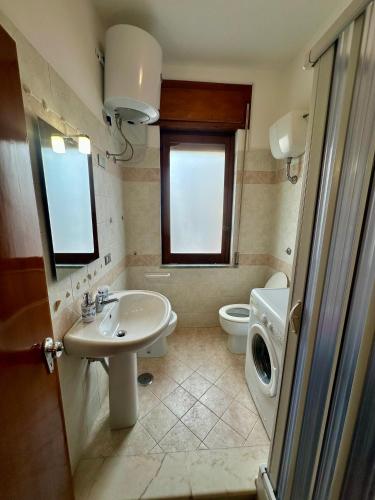 a bathroom with a sink and a toilet and a window at Domus Maris in Marina di Ascea