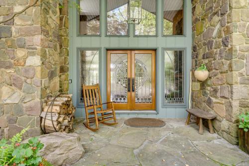 a porch with a wooden door and a chair at Luxe Poconos Pines Home with Beach and Amenities! in Pocono Pines