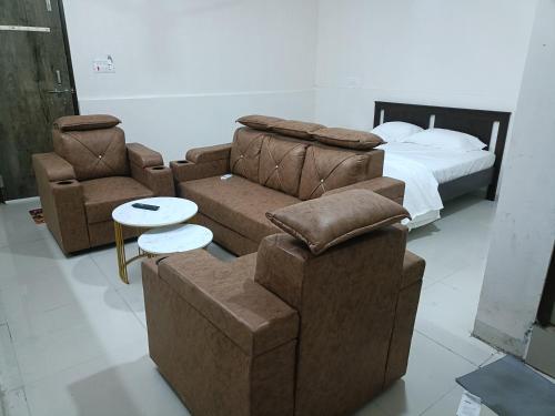 a bedroom with a couch and two chairs and a bed at RVR TOWN LODGe 