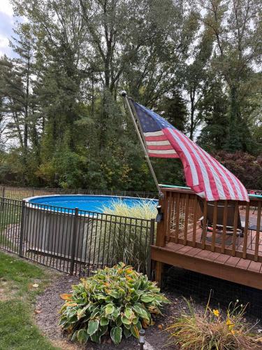 a bench with an american flag on it next to a pool at Off The Hook Spacious Home with Pool Firepit Large Yard in South Haven