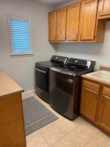 a kitchen with a black stove and a sink at Off The Hook Spacious Home with Pool Firepit Large Yard in South Haven