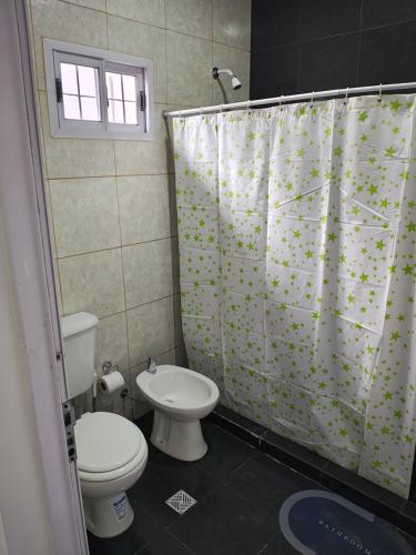 Un baño con inodoro y cortina de ducha. en Apartamento Los Churquis, en Rosario de la Frontera
