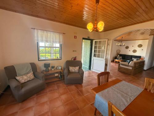 a living room with a couch and chairs and a table at Casa Amaral in Santo António
