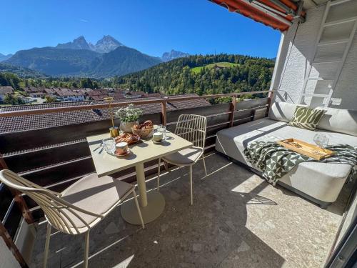 einen Balkon mit einem Bett, einem Tisch und Stühlen in der Unterkunft Bergherz Berchtesgaden in Berchtesgaden