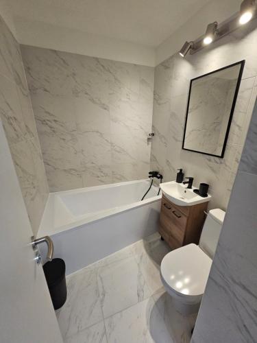un bagno con vasca, WC e lavandino di Apartment Lucia - Air-conditioned a Šamorín