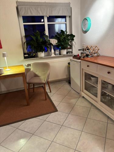 ヴェスターシュテーデにあるPrivatquartier im Ortskern von Westerstedeのキッチン(テーブル、椅子付)、窓が備わります。