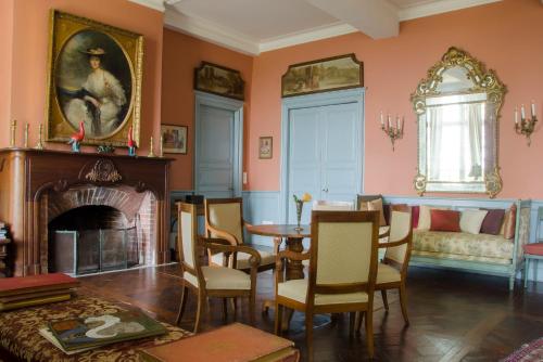 a living room with a fireplace and a table and chairs at Château d’Orion in Orion