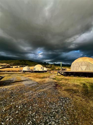 two domes in a field under a cloudy sky at Chadir yurd glamp in İsmayıllı
