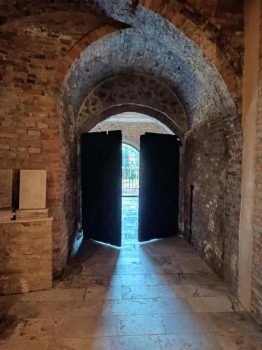 an archway in a castle with two black doors at Rocca degli Olivi in San Gimignano