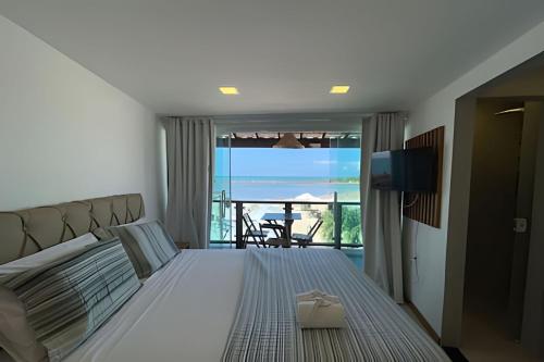 a bedroom with a bed with a view of the ocean at MAR DÁ LIBERDADE com Villa das Ondas in Morro de São Paulo