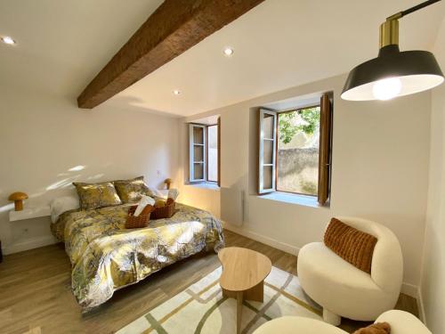 a bedroom with a bed and a chair and a window at Ô Berge De La Cité in Carcassonne