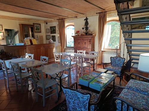 a dining room with tables and chairs and windows at Rocca degli Olivi in San Gimignano