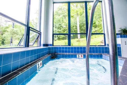 a hot tub in a room with windows at Ski-In, Ski-Out Sunrise Village Killington Condo - 2BR, Fireplace, Pool, Pet Friendly in South Sherburne