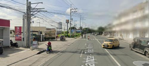 a yellow car is driving down a city street at Auntie's in Tanza