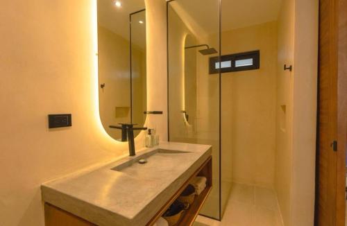 a bathroom with a sink and a glass shower at Tulum Getaway with Jacuzzi & Pools in Tulum