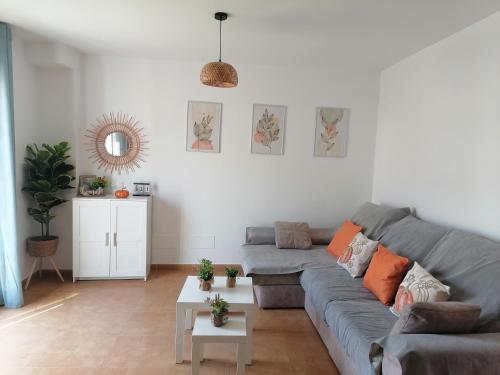 a living room with a gray couch and a table at Balcón del Mar in Málaga