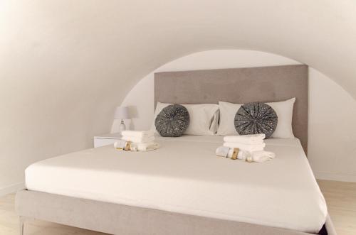 a bedroom with a bed with white sheets and pillows at San Pio - Cozy Apt Near Bari Central Station in Bari