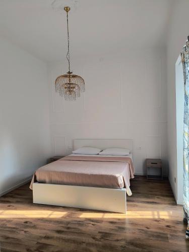 a bedroom with a bed and a chandelier at Appartamento Madonna 31 in Rho