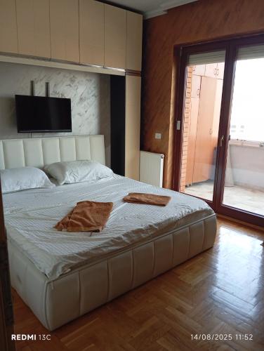 a bedroom with a large bed with a television on the wall at Bus Station Flat 32 in Prizren