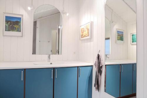 a bathroom with blue cabinets and a sink and a mirror at 13337-1-Hojby-Annettevaenget-8 in Højby