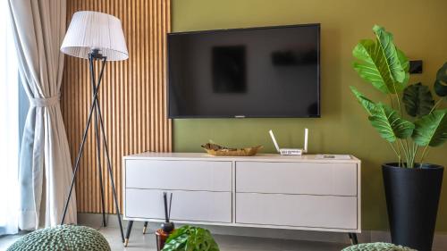 salon z białą komodą i telewizorem na ścianie w obiekcie CharmSlot at Nova EBS w Akrze