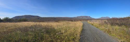 a dirt road in a field with mountains in the background at Aurora Oasis on the Golden Circle in Úthlid