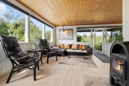 a living room with a couch and chairs and a fireplace at FJ1400-Jaegerspris-Thomsensvej-11 in Jægerspris