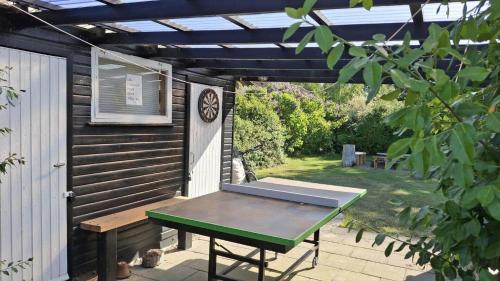 a picnic table on a patio with a pergola at FJ1400-Jaegerspris-Thomsensvej-11 in Jægerspris