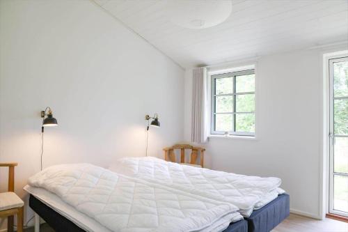 1 Schlafzimmer mit einem großen weißen Bett und 2 Fenstern in der Unterkunft 11126-1 Nykøbing Sj - Slåenhækken 18 in Nykøbing Sjælland