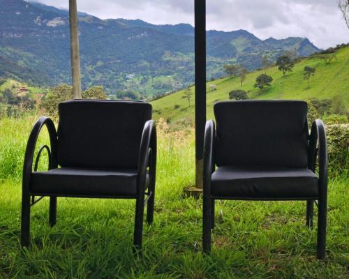 two chairs sitting in the grass with a view at Choachi casa colibri in Choachí