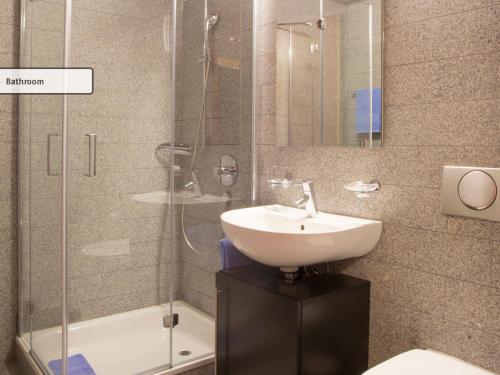 y baño con lavabo y ducha acristalada. en All In One Hotel - Inn Lodge / Swiss Lodge en Celerina