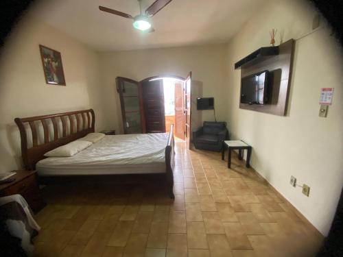 a bedroom with a bed and a chair in a room at Casa em Guaratinguetá-Casa da Rosa in Guaratinguetá