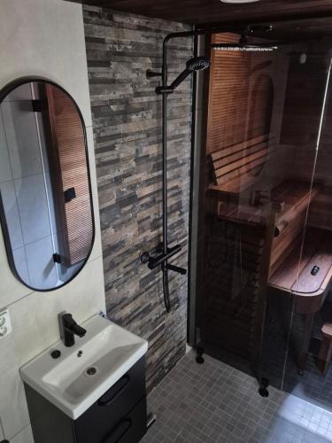 a bathroom with a sink and a shower and a mirror at Deluxe Luosto in Luosto