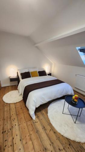 - une chambre avec un grand lit et 2 tapis dans l'établissement La belle chambre au fil de l'eau, à Douai