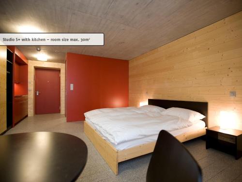 a bedroom with a bed and a table and chairs at All In One Hotel - Inn Lodge / Swiss Lodge in Celerina