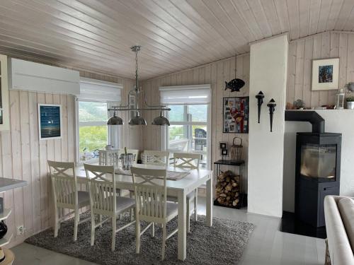 a dining room with a white table and chairs at Cabin with stunning views and outdoor jacuzzie in Leset