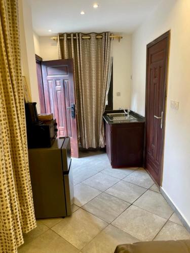 a room with a bathroom with a sink and a door at Résidence Prestige KGV in Douala