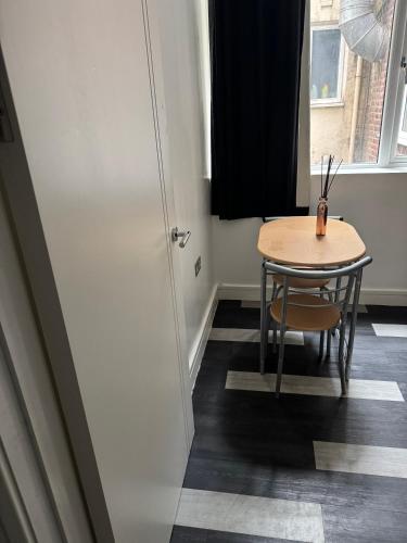 a small table and chair in a room with a window at One bed flat Northampton town in Northampton